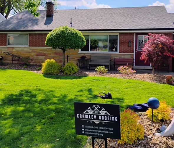 A house with a well-maintained yard displays a sign for Crawley Roofing, highlighting their roofing services prominently.